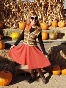 Girl in retro fall outfit with swing skirt and sweater vest